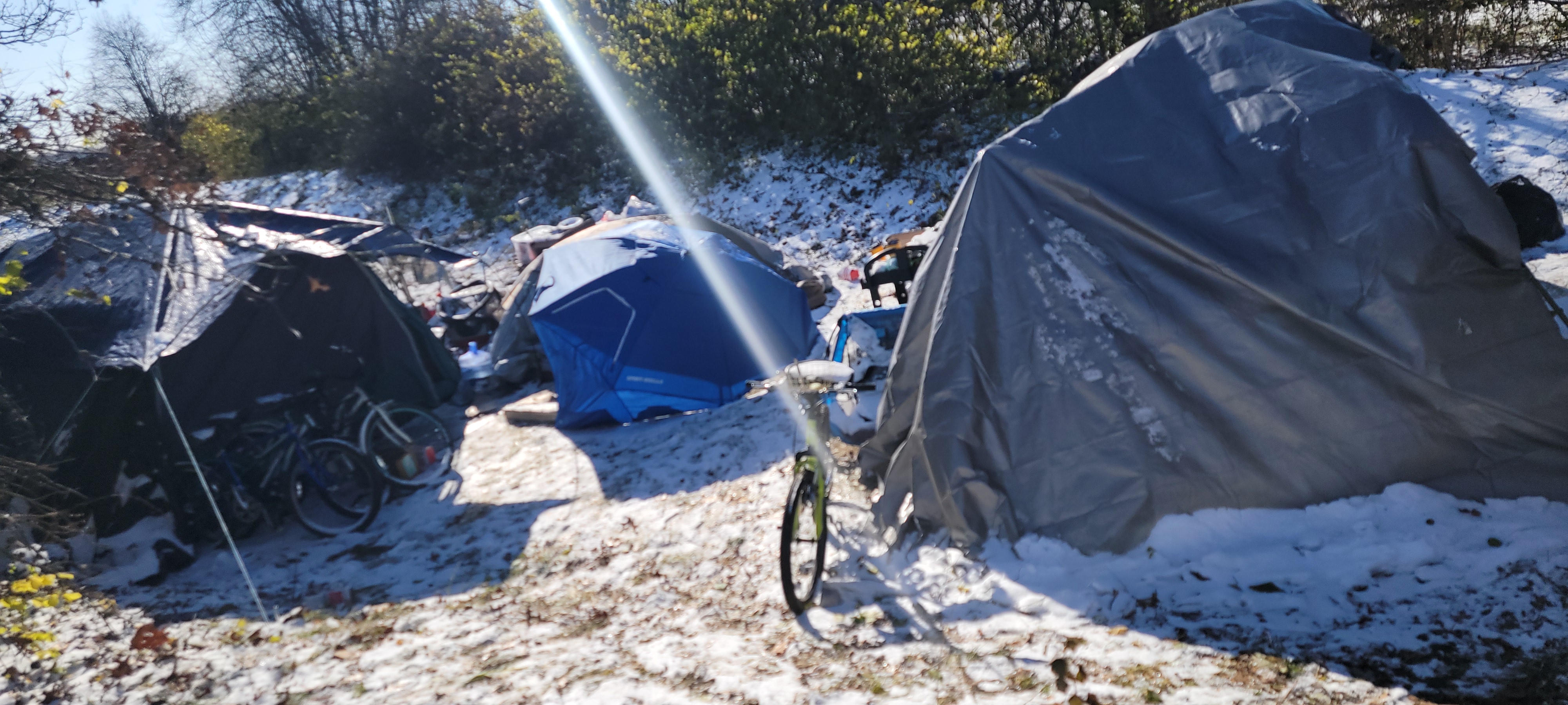 An outdoor living area beneath a large urban bridge